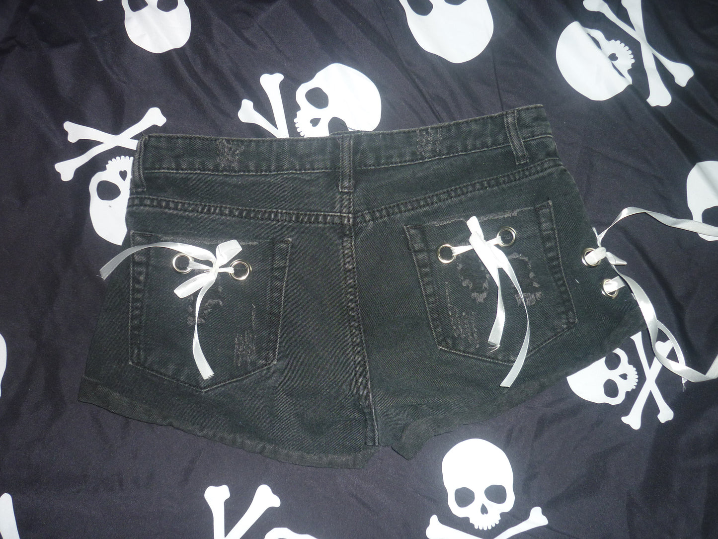 Black shorts with hand sewn white ribbons